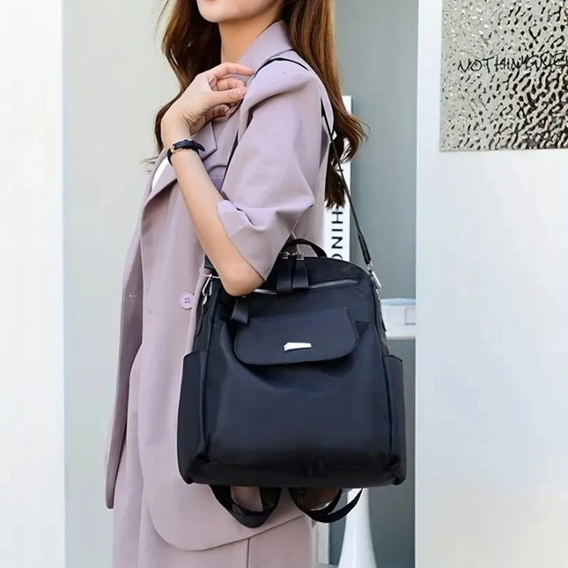 Dámský batoh 2v1 GP74 černý nošený přes rameno jako kabelka – stylový městský batoh z nepromokavého materiálu Oxford.