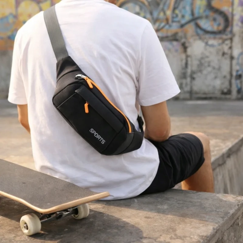 Černá sportovní ledvinka T16 nošená přes záda při jízdě na skateboardu – praktická voděodolná ledvinka na sport, výlety i cestování.