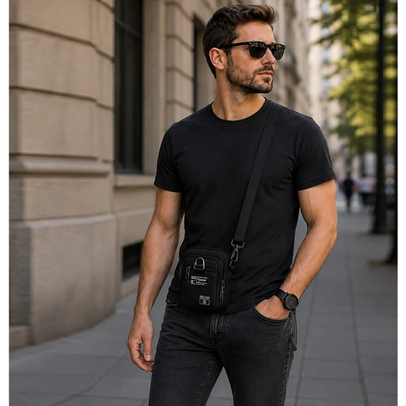 Muž s černou pánskou taštičkou SPORTS R12 přes rameno v městském prostředí. Malá crossbody taštička na telefon, doklady, peněženku a klíče pro každodenní nošení.